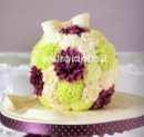 A ball shaped cake covered in sugar flowers