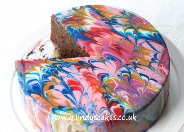 Beautiful artistic mirror glaze patterns created with a simple cocktail stick by Lindy Smith