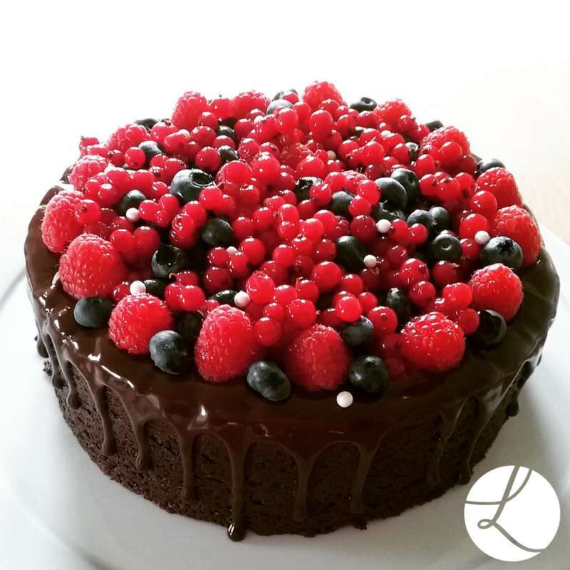 Chocolate fudge cake with chocolate drips and fresh fruit